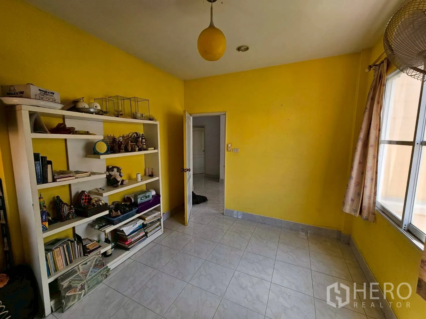 Detached House for rent or sale in Bang Lamung, Chon Buri - Yellow bedroom with open shelving and tiled flooring.