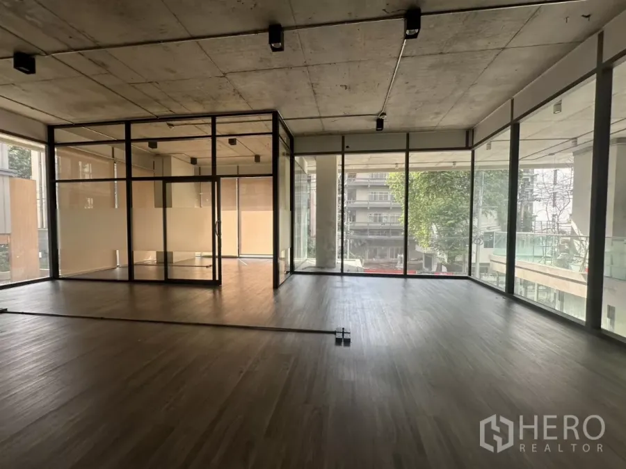 零售空间 出租 - 采光充足的开放式零售空间，木纹地板、裸露混凝土顶及玻璃隔间，落地窗望向街景。