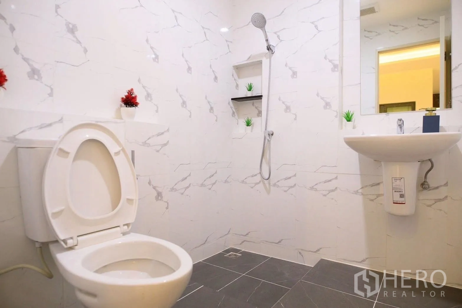 Townhouse for rent or sale in Bang Phli, Samut Prakan - Modern bathroom with marble-look tiles, handheld shower, pedestal sink and toilet.