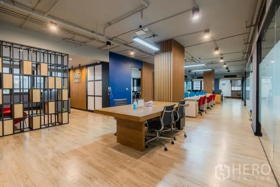 Office Space for rent - Open-plan Thonglor office with wood floors, long worktable, glass partitions and ceiling lights.