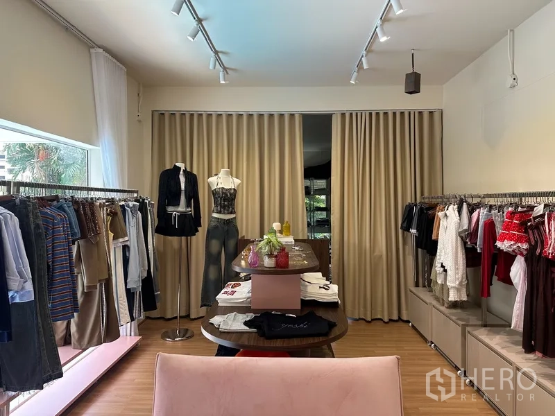 Retail Space for rent in Khlong Toei, Bangkok - Retail room with mannequins, center display island, floor-to-ceiling curtains, and racks on both sides.