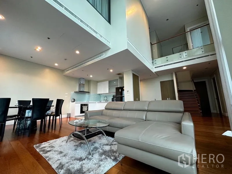 คอนโด ให้เช่าในKhlong Toei, Bangkok - พื้นที่นั่งเล่นสไตล์เพดานสูงดับเบิล โอเพนแปลนครัว โต๊ะทานข้าว และโซฟาหนัง