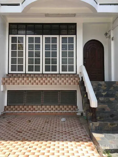 ทาวน์เฮาส์ ให้เช่าในPhra Khanong, Bangkok - ด้านหน้าทาวน์เฮ้าส์ มีบันไดหิน ทางเข้าโค้ง และหน้าต่างกรอบขาวขนาดใหญ่