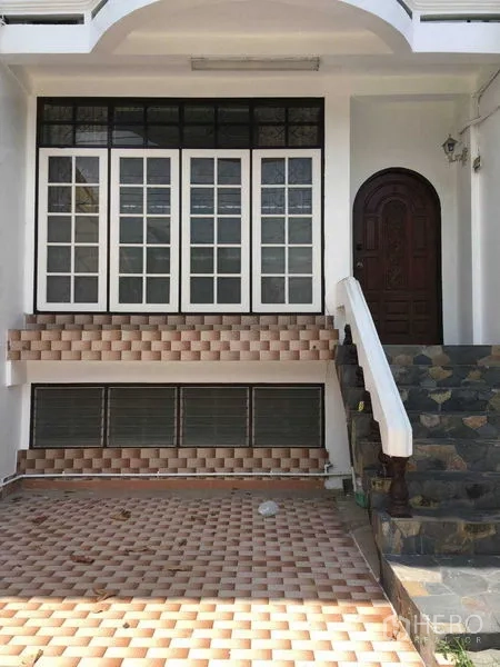 ทาวน์เฮาส์ ให้เช่าในPhra Khanong, Bangkok - ด้านหน้าทาวน์เฮ้าส์ มีบันไดหิน ทางเข้าโค้ง และหน้าต่างกรอบขาวขนาดใหญ่