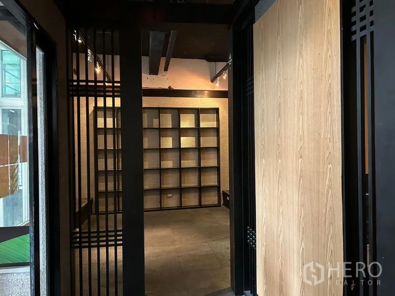 พื้นที่ขายปลีก ให้เช่าในBang Rak, Bangkok - โถงทางเข้าเชื่อมสู่ห้องแสดงสินค้า พร้อมชั้นวางแบบตารางเต็มผนังและไฟสปอตไลต์