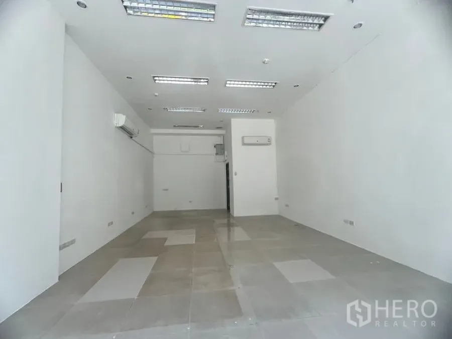 พื้นที่ขายปลีก ให้เช่าในKhlong Toei, Bangkok - พื้นที่ร้านค้าโทนสีขาวสว่าง พื้นกระเบื้อง ไฟฟลูออเรสเซนต์ฝังฝ้า และแอร์แขวนผนัง