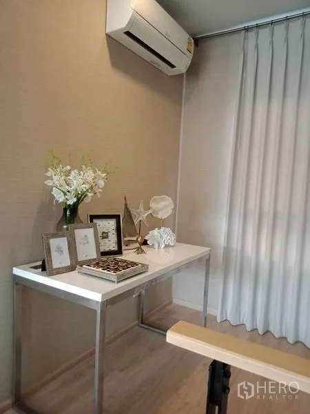 ทาวน์เฮาส์ ให้เช่าหรือขายในSuan Luang, Bangkok - มุมทำงานขนาดกะทัดรัด มีเครื่องปรับอากาศ โต๊ะสีขาว และของตกแต่งข้างผ้าม่านยาว