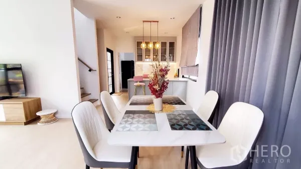 บ้าน ให้เช่าในLat Krabang, Bangkok - โต๊ะทานอาหาร 4 ที่นั่ง ข้างเคาน์เตอร์เกาะกลางครัวพร้อมโคมไฟแขวนและบันได