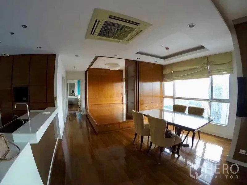 Condominium for rent or sale in Khlong San, Bangkok - Dining area with raised wooden platform room, recessed ceiling and large windows.
