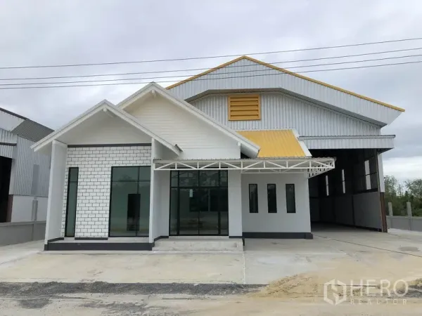 工厂 出租或出售在Sai Noi, Nonthaburi - 新建工厂外观，带前置办公区、落地玻璃与黄色点缀金属屋顶。