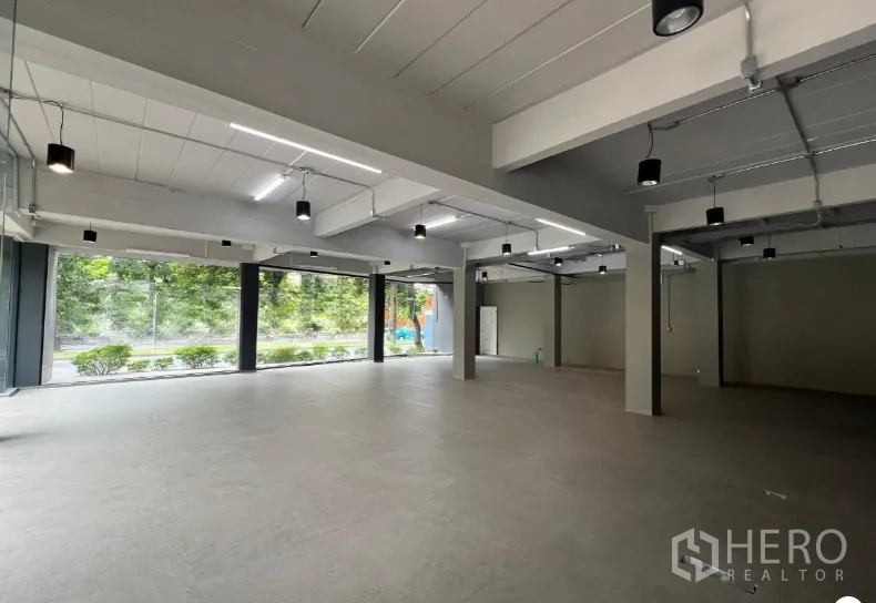 零售空间 出租在Suan Luang, Bangkok - 开阔的零售开间空间，层高通透，吊灯与落地窗采光充足。