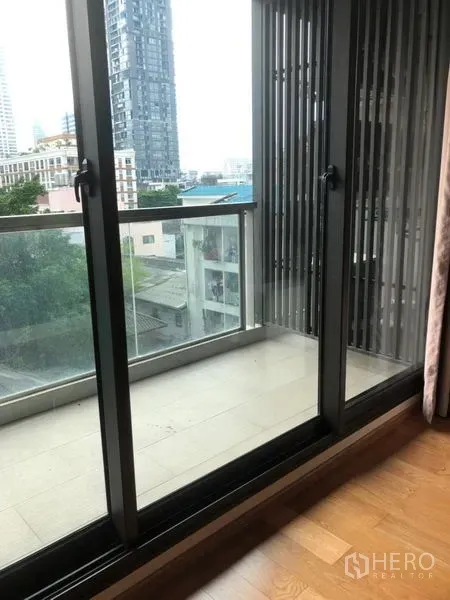 公寓 出售在Bang Rak, Bangkok - 推拉玻璃门通向私人阳台，眺望城市天际线。