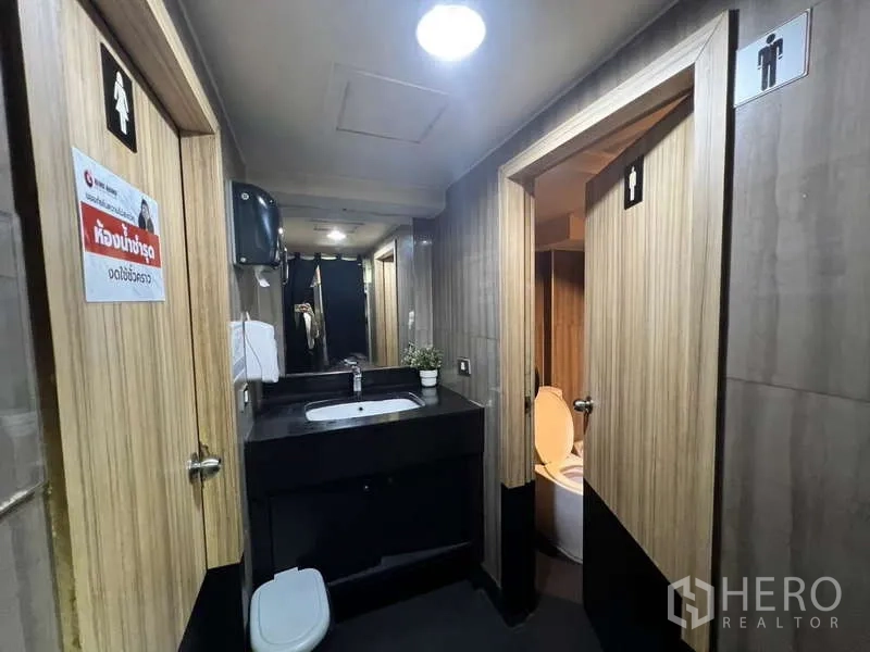 店屋 出租或出售在Khlong Toei, Bangkok - 洗手间走廊，含洗手台、镜子与男女分厕门
