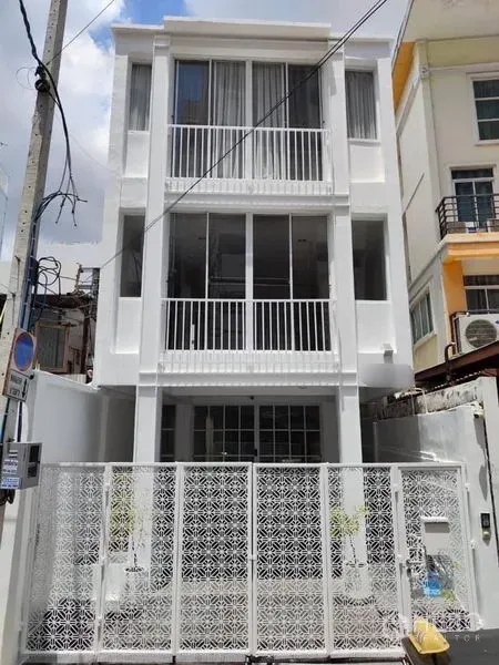 Townhouse for sale in Din Daeng, Bangkok - Renovated three-storey white townhouse facade with balconies and a patterned metal gate in Din Daeng, Bangkok.