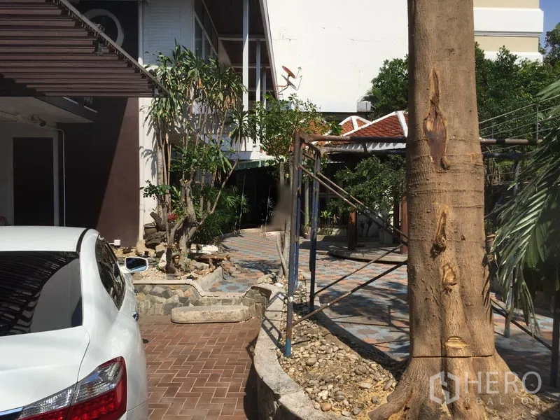 零售空间 出租在Khlong Toei, Bangkok - 庭院花园，有成树、石径与休憩区，毗邻主楼。