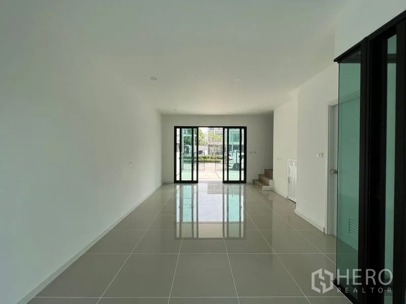 Townhouse for rent in Bang Kapi, Bangkok - Open-plan ground floor with double sliding doors to the front patio and glossy tiled floor.