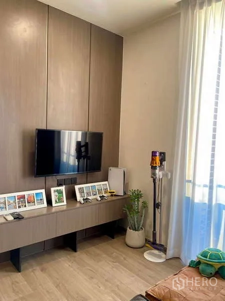 Condominium for rent - TV wall with floating console and large window bringing daylight into the living area.