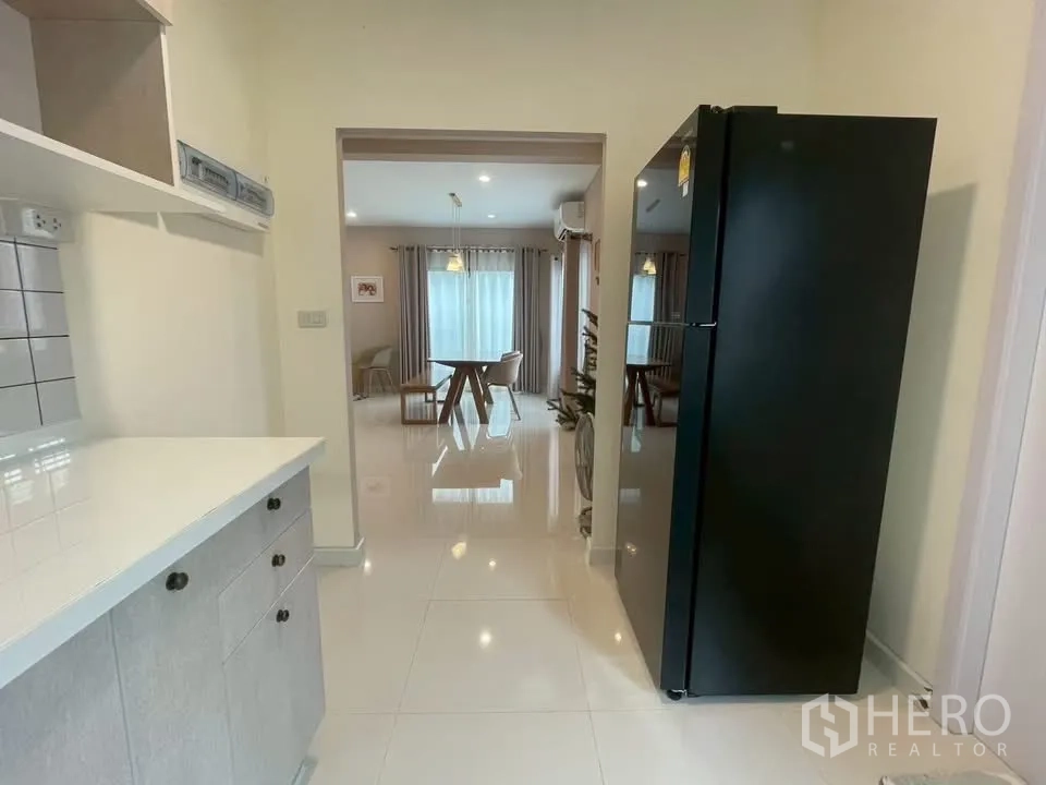 Detached House for rent in Bang Phli, Samut Prakan - Pantry corridor with a black refrigerator opening to the dining area.