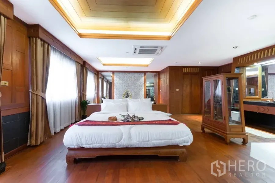 Condominium for rent or sale in Ratchathewi, Bangkok - Spacious master bedroom with coffered ceiling, warm wood paneling and large windows.