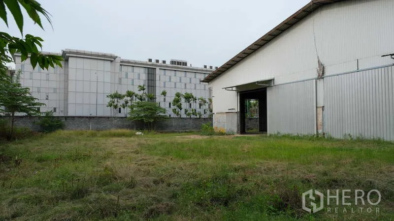Factory for rent in Bang Phli, Samut Prakan - Grassy yard beside the factory building, suitable for truck parking and loading.