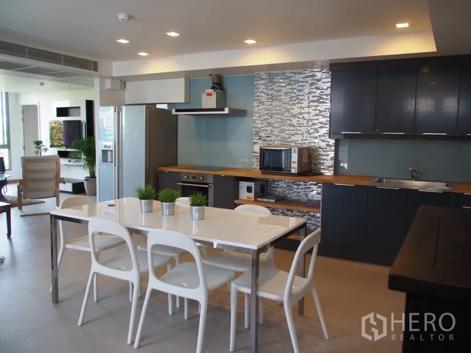 คอนโด for rent or sale in Watthana, Bangkok - ครัวและพื้นที่รับประทานอาหารแบบเปิด พร้อมตู้ครัว ผนังกระเบื้อง และเครื่องใช้ไฟฟ้า