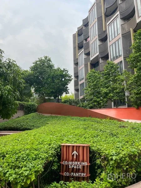 คอนโด ขายในWatthana, Bangkok - ทางเดินสวนเขียวพร้อมป้ายไปโคเวิร์กกิ้งสเปซและส่วนครัวเล็ก