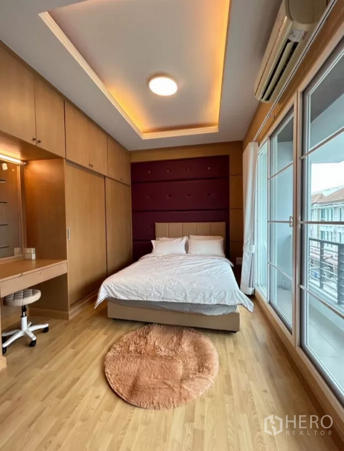 Townhouse for rent in Wang Thonglang, Bangkok - Primary bedroom with built-in wardrobes, desk and balcony access