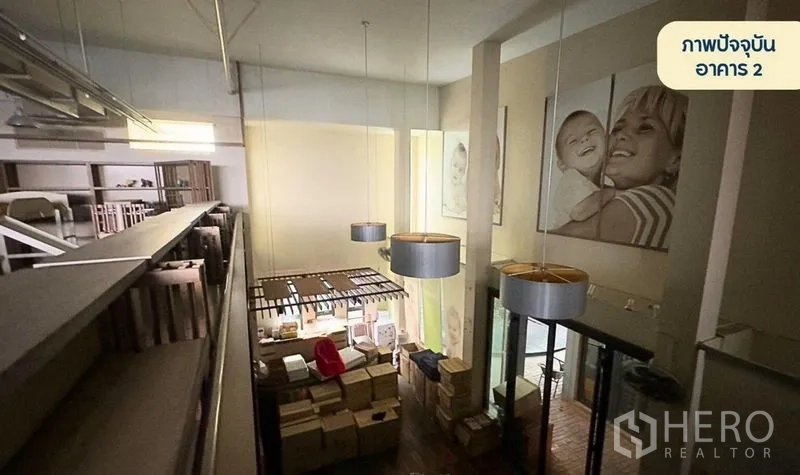 零售空间 出租在Wang Thonglang, Bangkok - 第二栋建筑的双层挑高展厅，吊灯与夹层相连。