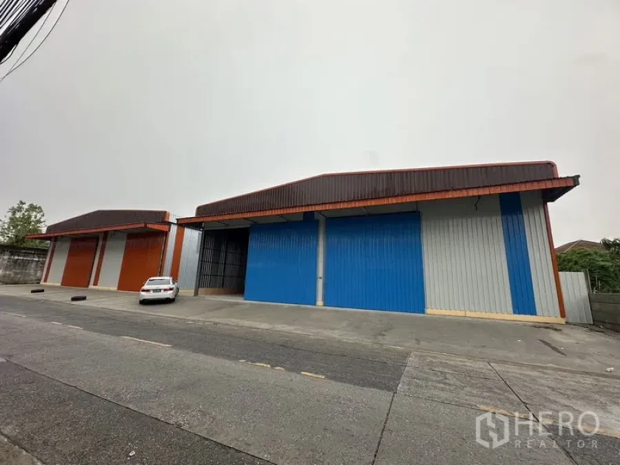 货栈 出租在Bueng Kum, Bangkok - 多单元仓库的宽阔正立面，前方有停车与通道。