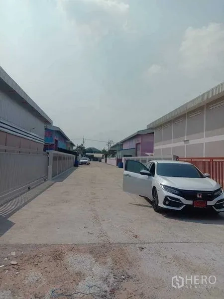 Warehouse for rent in Pathum Thani - Wide concrete access road between modern warehouses in Lat Lum Kaeo, Pathum Thani.
