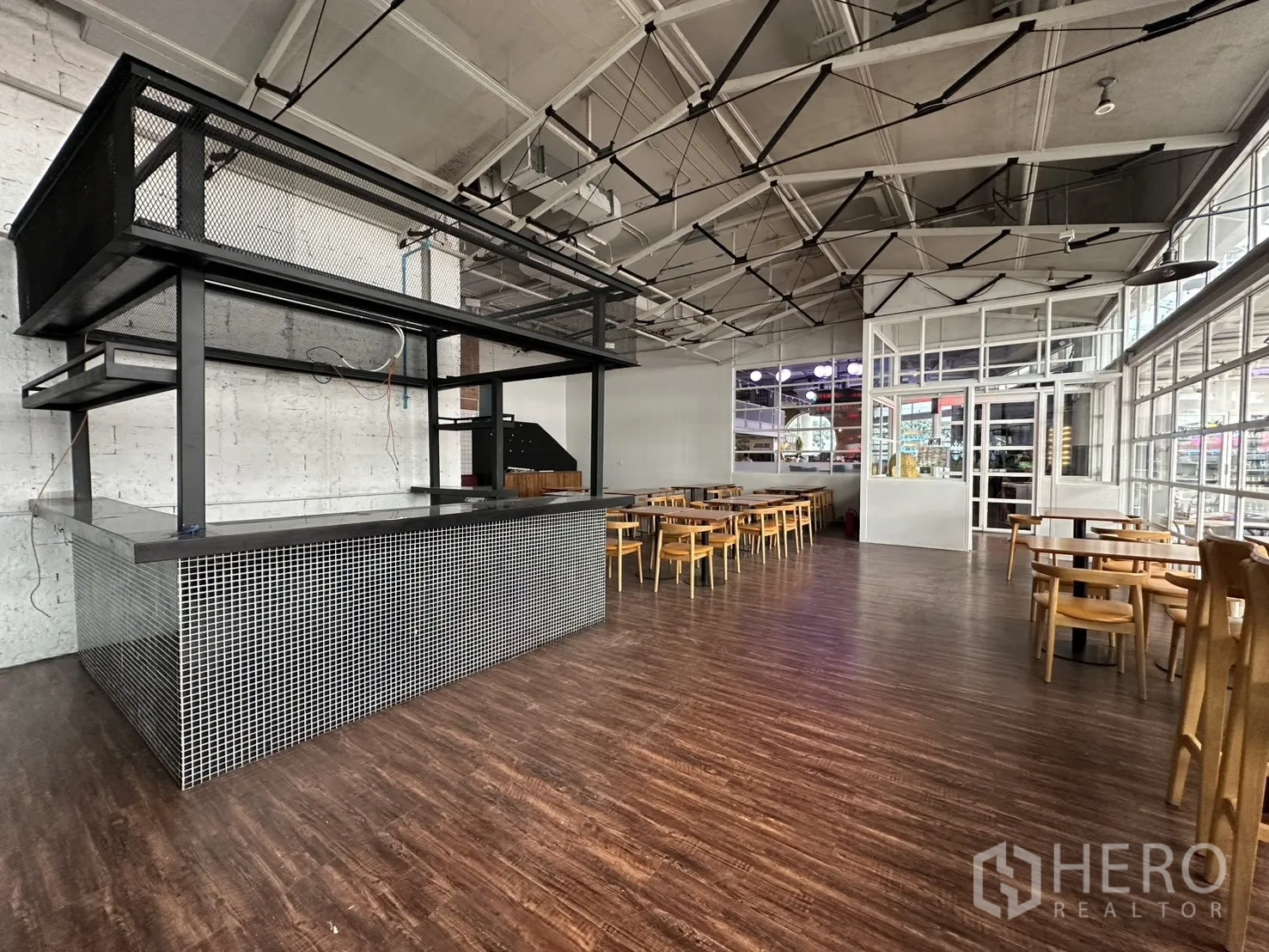 零售空间 for rent in Watthana, Bangkok - 宽幅视角展示吧台、桌椅与桁架式天花。