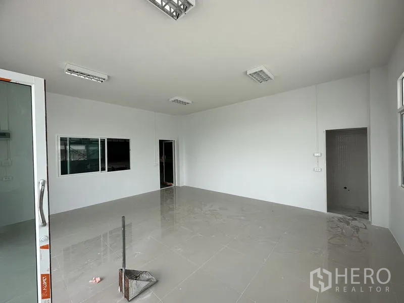 Factory for rent in Pathum Thani - Clean office interior with tiled floors, sliding door and access to restroom.