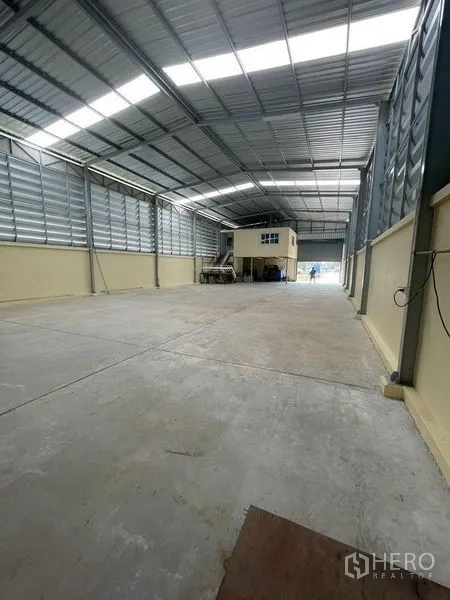 Warehouse for rent in Lam Luk Ka, Pathum Thani - Deep warehouse bay showing mezzanine office box and front loading door.