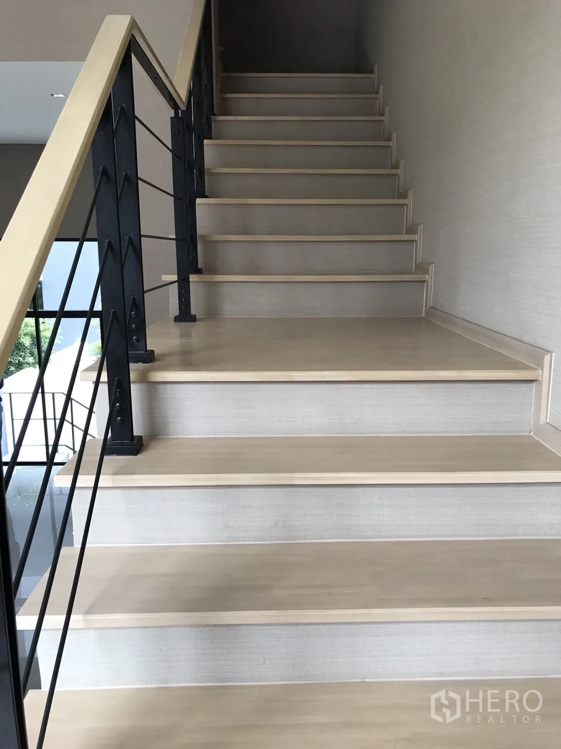 ทาวน์เฮาส์ ขายในSuan Luang, Bangkok - ภาพระยะใกล้ของบันไดไม้กับเสาเหล็ก และผนังโทนกลาง