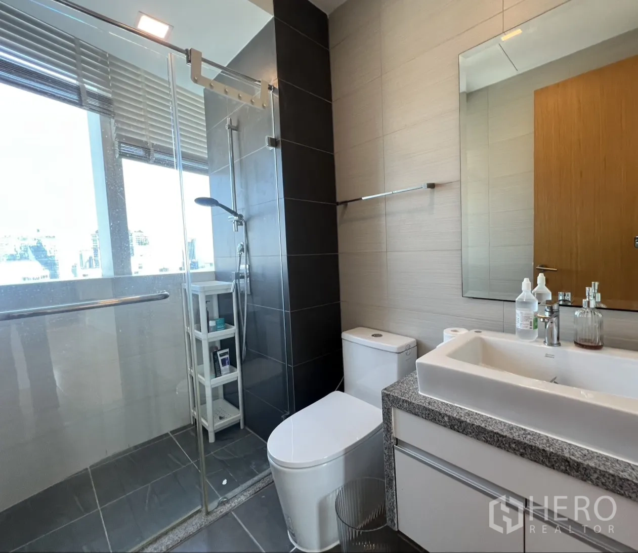 คอนโด for sale in Khlong Toei, Bangkok - ห้องน้ำมีหน้าต่าง ฝักบัวแบบเรนชาวเวอร์ ในตู้กระจก เคาน์เตอร์หิน