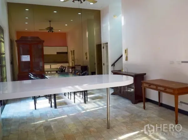 Townhouse for rent in Pathum Wan, Bangkok - Open-plan dining area with long white counter and mirror wall.