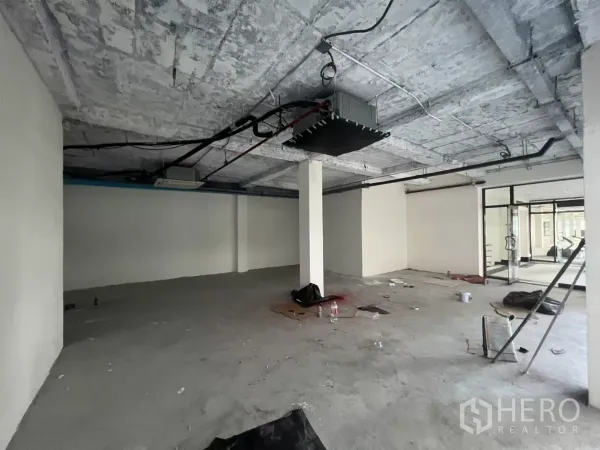 零售空间 出租在Watthana, Bangkok - 原始状态室内，立柱、混凝土地面与玻璃入口，适合二次装修。