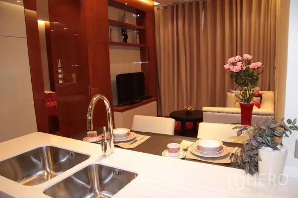 คอนโด ให้เช่าในKhlong Toei, Bangkok - ครัวแบบเปิดพร้อมโต๊ะทานอาหารสำหรับสองคน เชื่อมต่อห้องนั่งเล่นพร้อมชั้นวางทีวีในคอนโดเขตคลองเตย