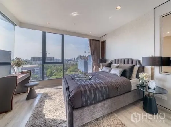 公寓 出租在Bang Na, Bangkok - 主卧配落地转角窗与软包大床，享邦纳公寓城市天际线景观。