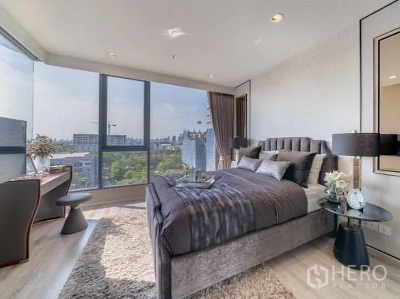 公寓 出租在Bang Na, Bangkok - 主卧配落地转角窗与软包大床，享邦纳公寓城市天际线景观。
