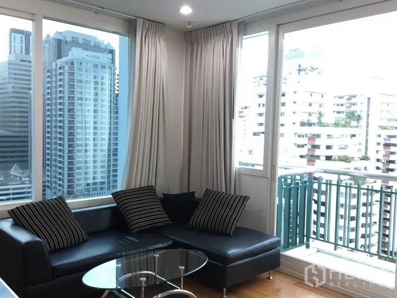 Condominium for rent in Watthana, Bangkok - Bright living room with corner windows, balcony and city skyline view.