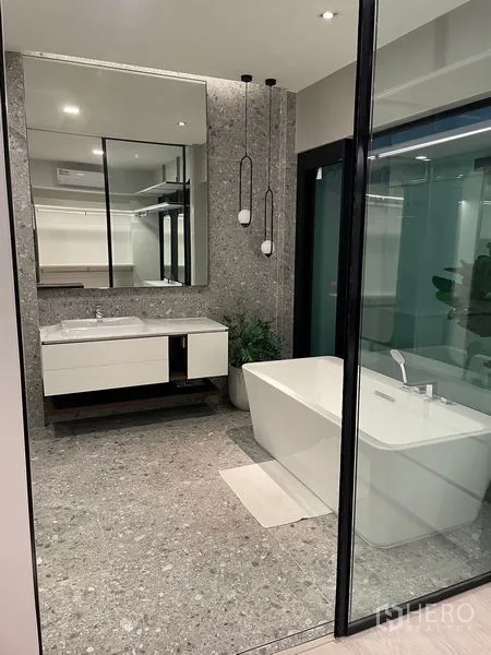 Detached House for sale in Saphan Sung, Bangkok - Elegant bathroom with freestanding tub, terrazzo flooring and pendant lights.
