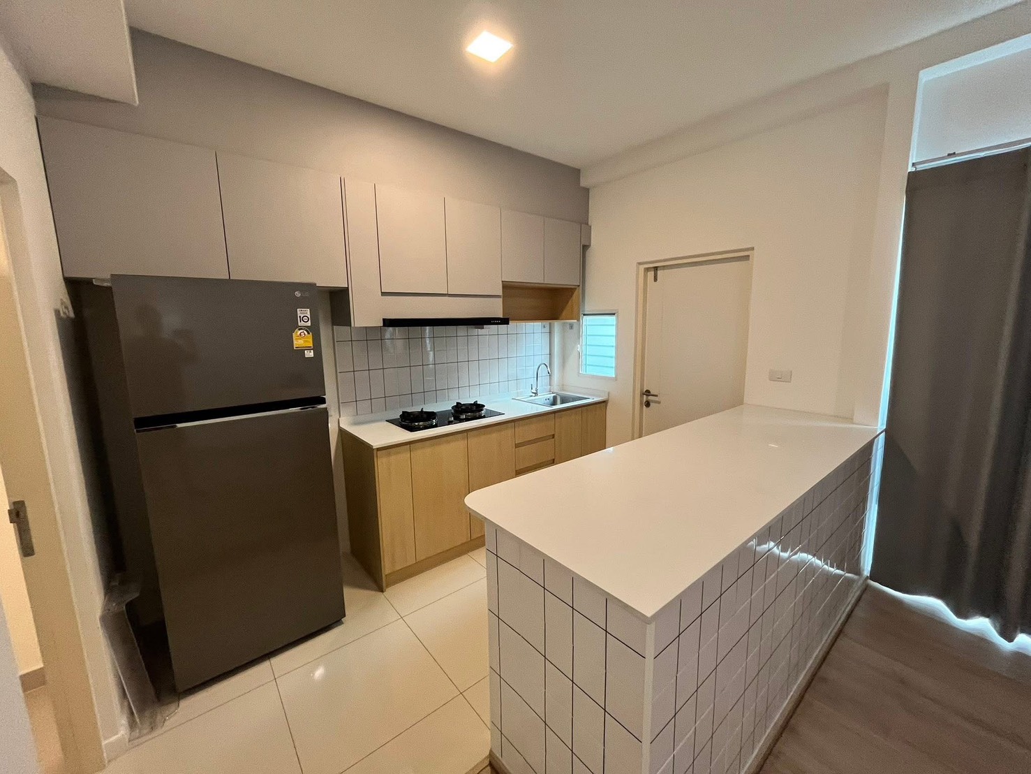 联排别墅 for rent in Prawet, Bangkok - 整体厨房，燃气灶、瓷砖防溅板、大冰箱与吧台。