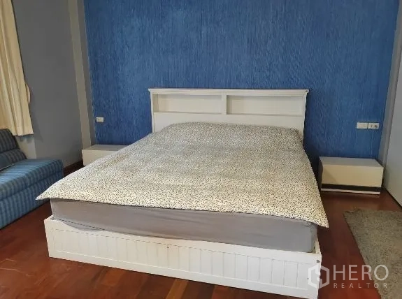 Detached House for rent in Huai Khwang, Bangkok - Bedroom with white bed and blue feature wall