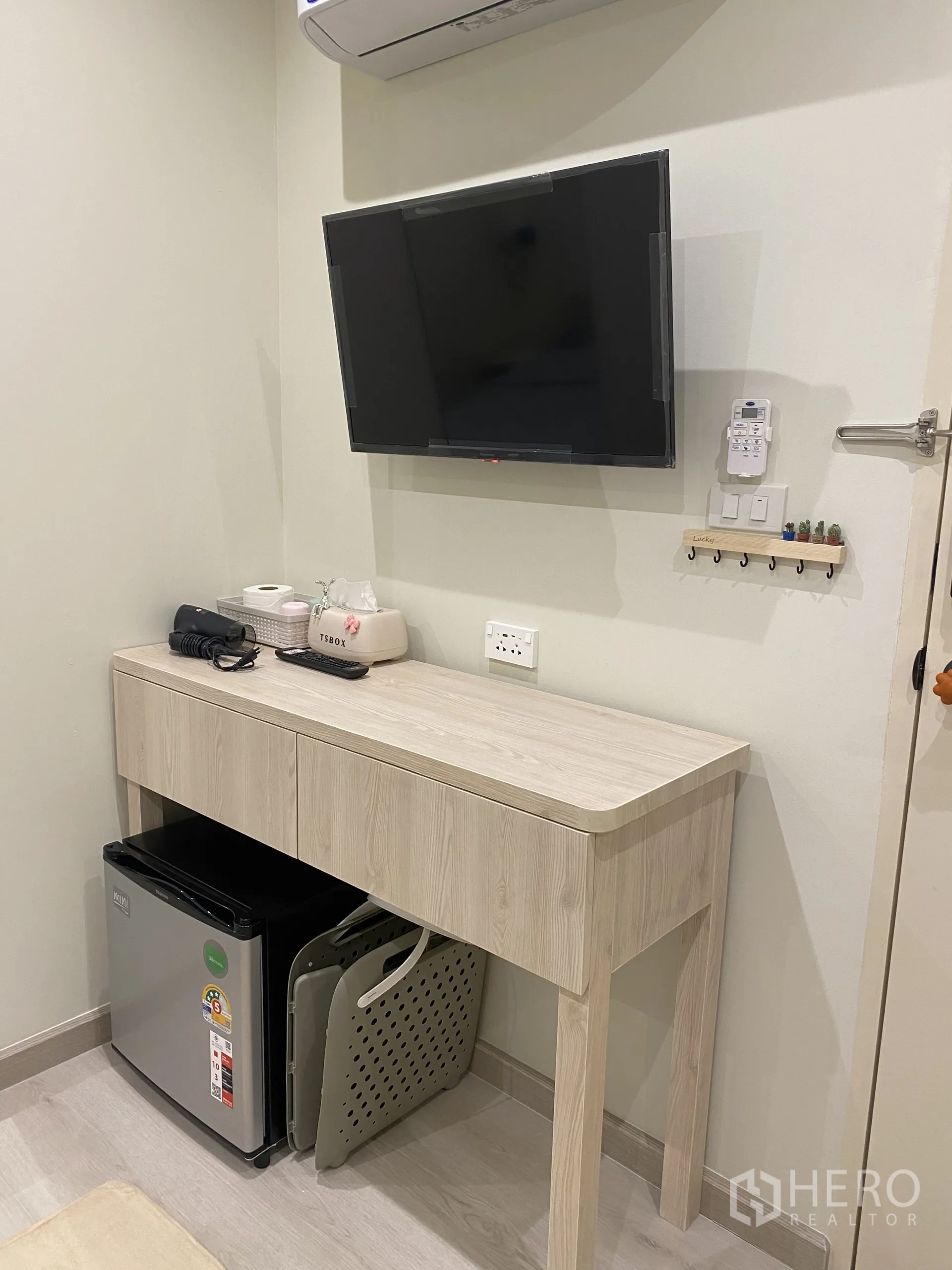 อาคารพาณิชย์ ให้เช่าในWatthana, Bangkok - ทีวีติดผนังเหนือโต๊ะไม้สีอ่อนและตู้เย็นเล็ก