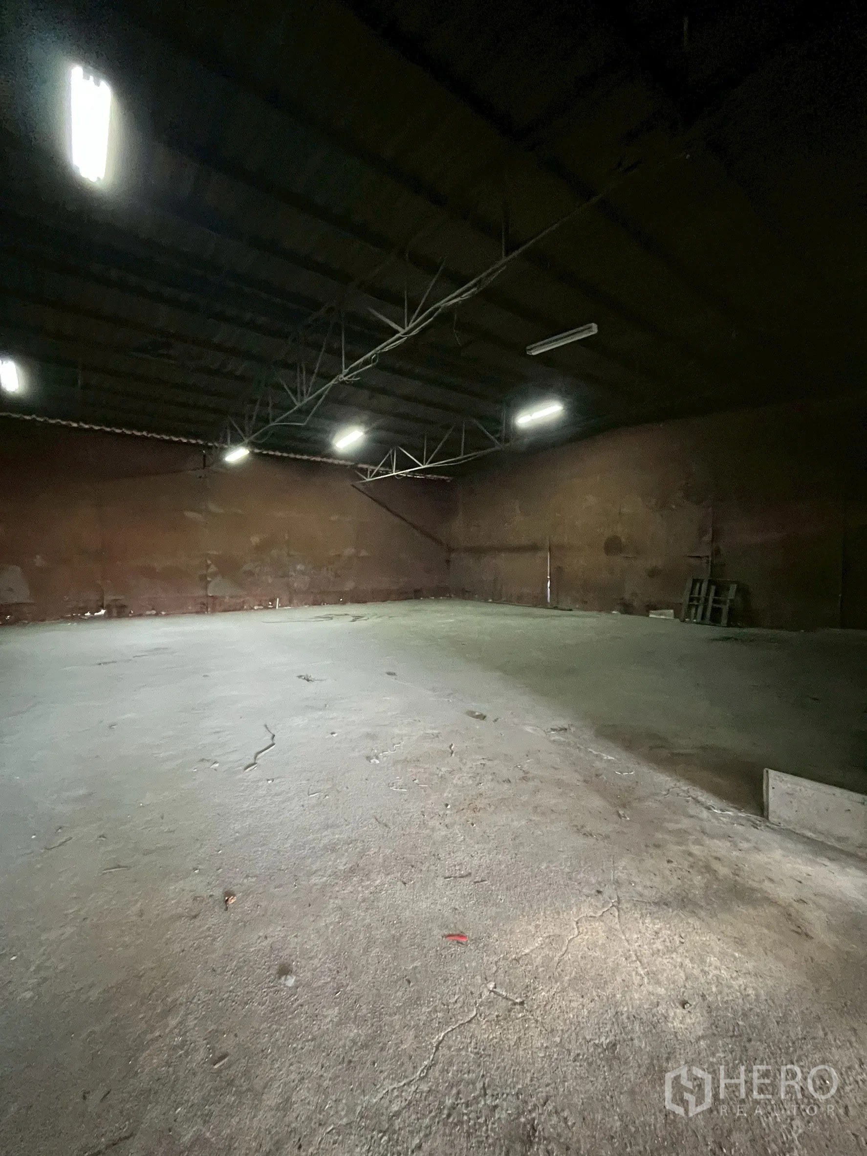 工厂 for rent in Phra Pradaeng, Samut Prakan - 封闭仓间内部，荧光灯照明与混凝土地面。