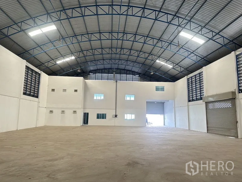 Factory for rent in Bang Bo, Samut Prakan - High-clear production hall with twin roller shutters and a rear loading bay.