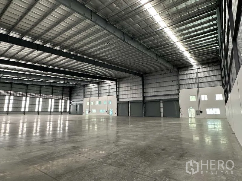 工厂 出租在Bang Sao Thong, Samut Prakan - 朝向办公区与装卸门的厂房内部，高挑屋顶下的宽阔空间