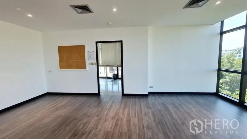 Office Space for rent in Watthana, Bangkok - Open-plan room with doorway to the pantry and corner glass windows.