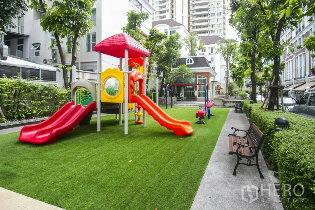 Townhouse for rent in Watthana, Bangkok - Communal playground with slides and benches inside the townhouse compound.